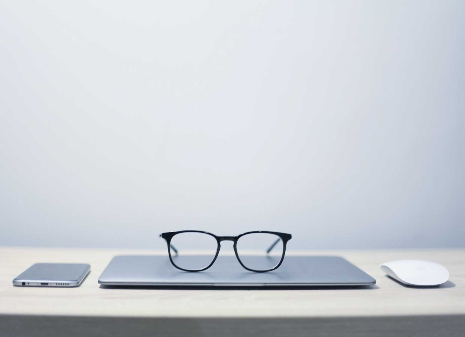 iphone, laptop and mouse in row on desktop