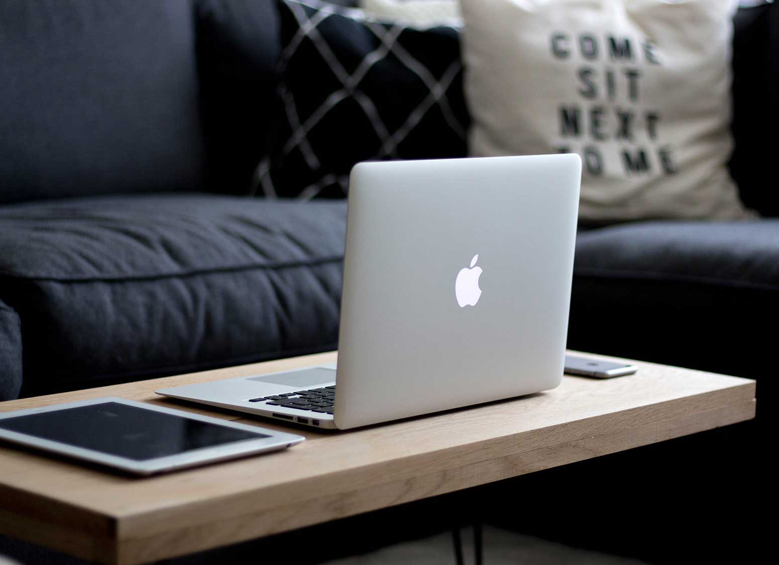 tablet, laptop and smartphone on coffee table