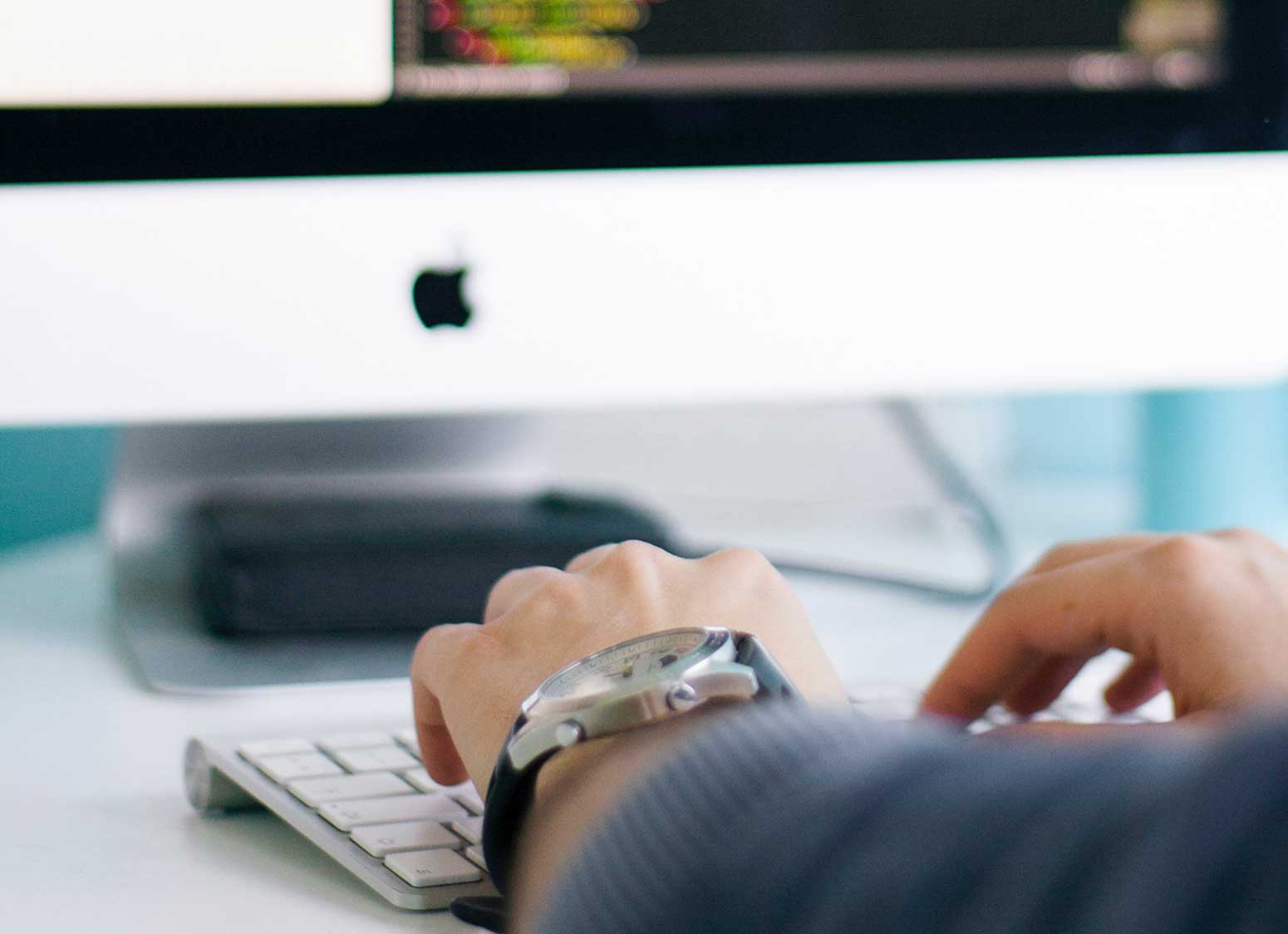 man typing on a mac