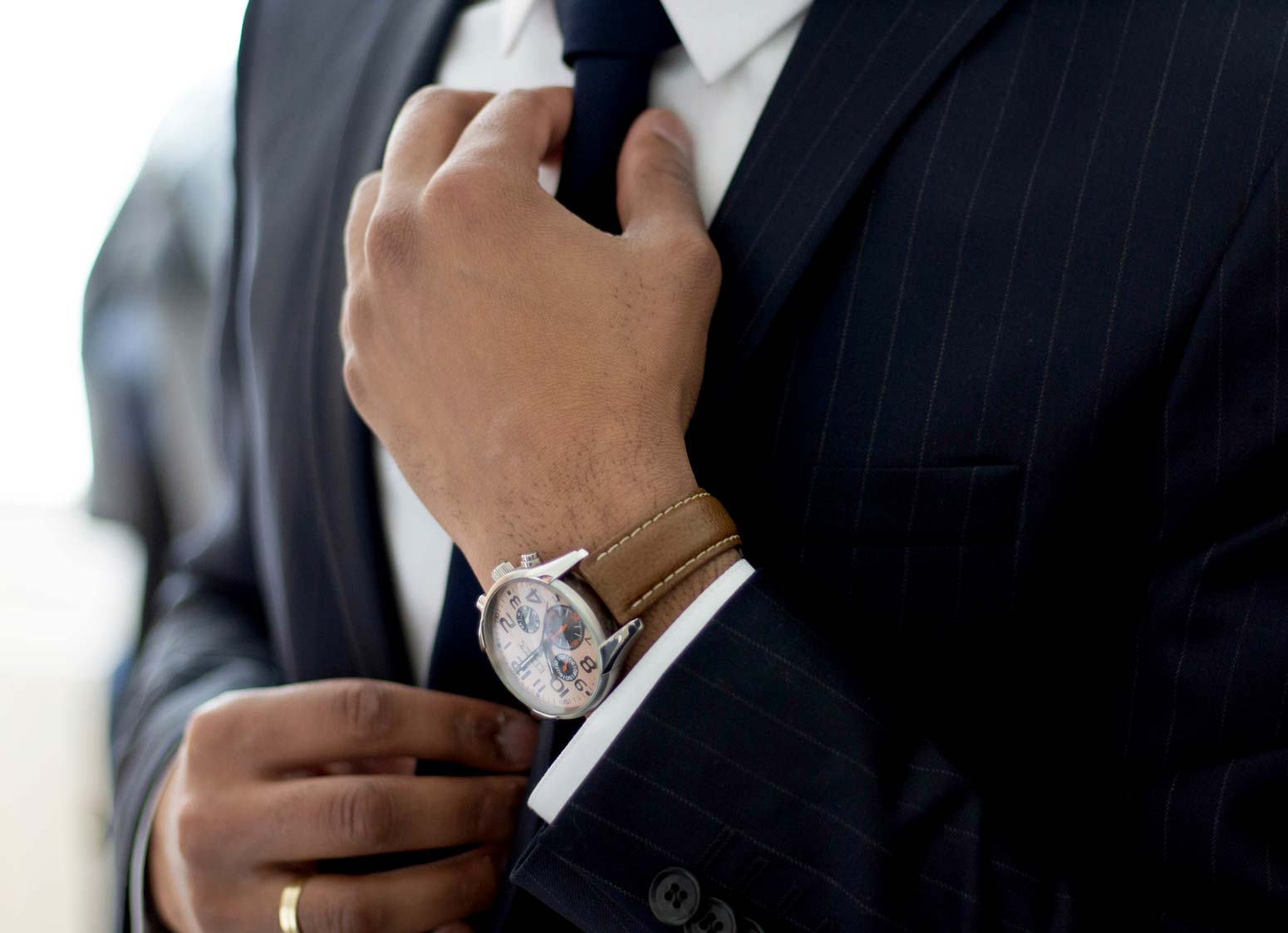 man adjusting tie