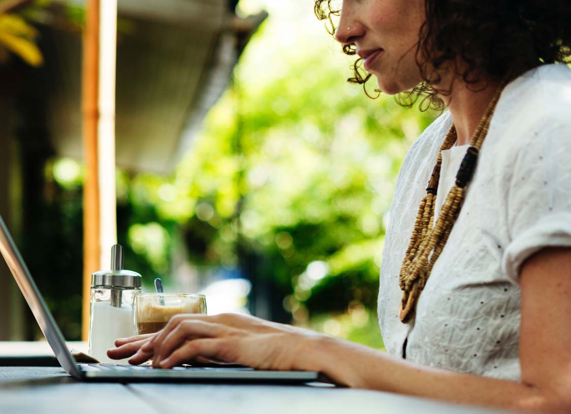 woman typing on laptop outdoors