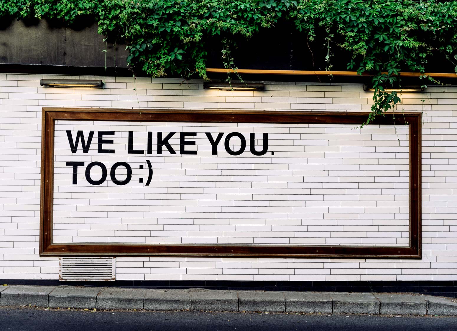 billboard that reads "we like you too" with emoji smile