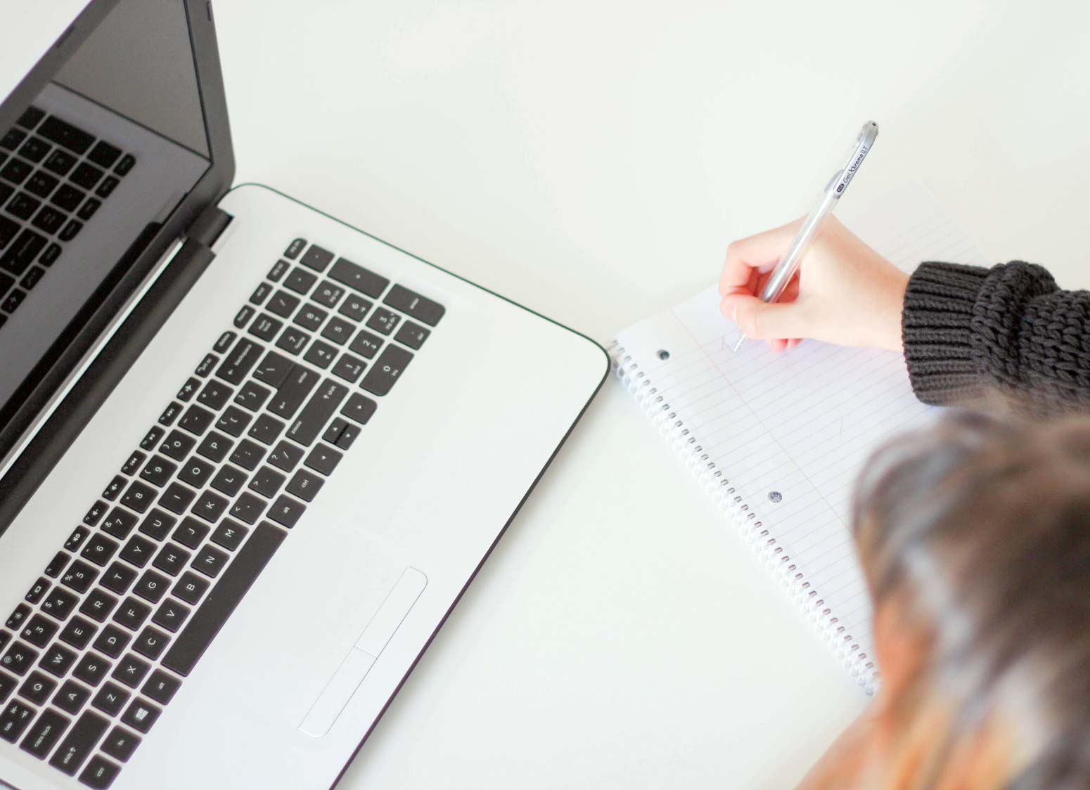 woman taking notes at laptop